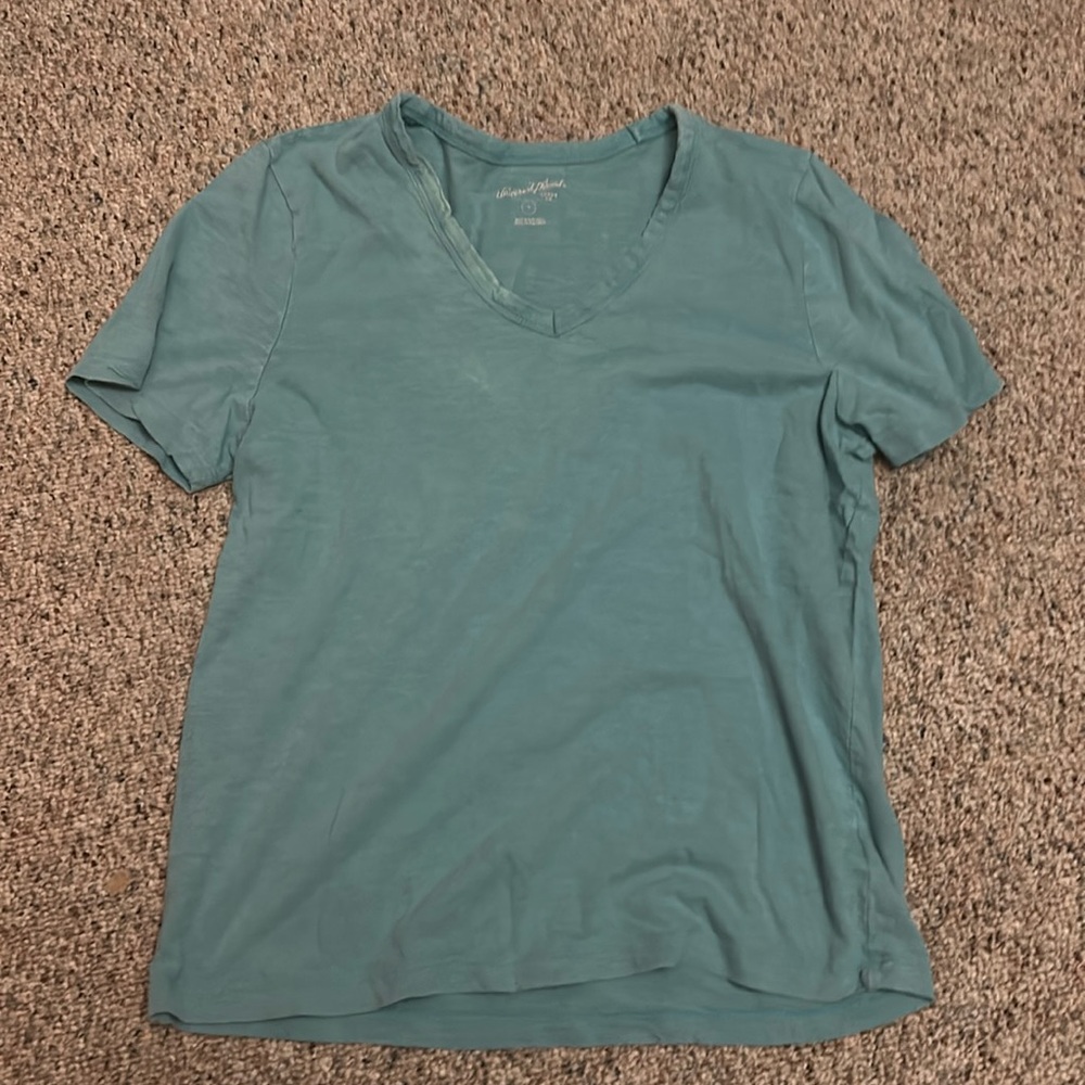 Teal ish blue shi with a v-neck and short sleeves